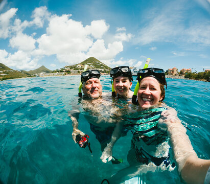 Happy family taking a selfie while snorkeling in the ocean