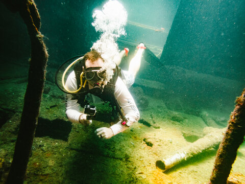 Scuba diver films underwater with action camera