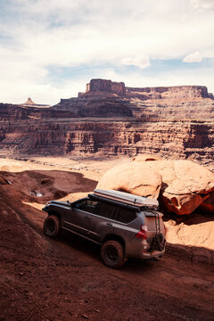 Dark SUV off roading on a steep desert trail