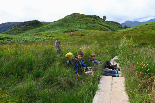 Two kids take a break on a hike in the highlands on West Highland Way
