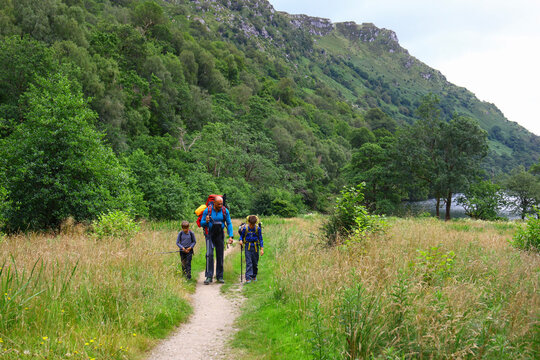 Father and two children hiking together in the countryside