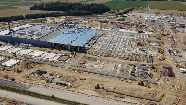 Aerial view of a large data center construction site with steel framework, heavy machinery, and earthworks in Kronstorf, Upper Austria, Austria.