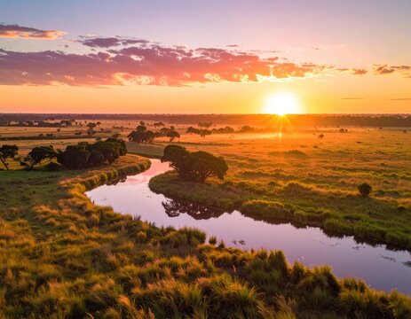 Scenic sunrise over a winding river and savanna landscape.