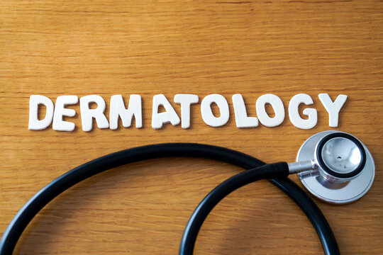 The word dermatology formed with wooden letters, accompanied by a black medical stethoscope.
