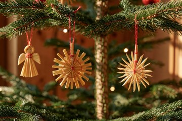 Obraz premium Traditional Czech straw star and angel ornaments hanging from evergreen Christmas tree branches, illuminated by warm lights in a festive indoor holiday setting