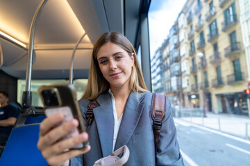 Young woman commuting on public bus using smartphone © unai