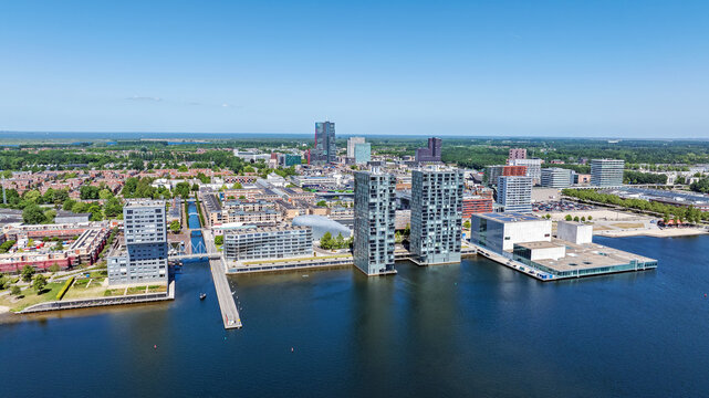 Aerial view of modern skyscrapers and contemporary architecture along the waterfront of the Weerwater lake in the city center of Almere, Flevoland, Netherlands.