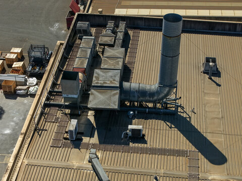 Aerial view of industrial ventilation systems and exhaust stacks on a corrugated metal rooftop in Kilsyth, Victoria, Australia.