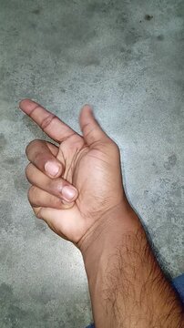 Male hand displaying a metaphorical finger gun gesture, symbolizing targeting, clicking, or aiming at a business objective