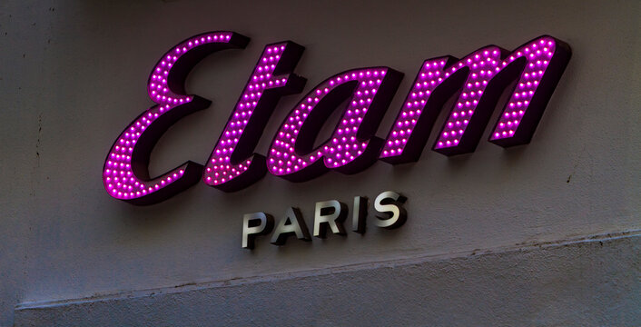 Seville, Spain &ndash; December 29, 2025: Close-up of the illuminated Etam Paris sign on a retail storefront.
