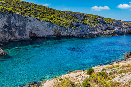 Breathtaking Greek cove turquoise crystal sea white limestone cliffs rocky coast summer paradise. Peaceful nature seascape landscape scene. Scenic Mediterranean travel tranquil wellbeing escape