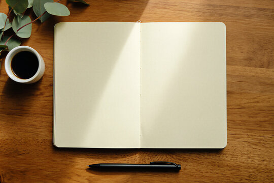 Blank notebook with coffee and pen on wooden desk