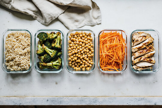 Overhead view of meal prep containers with rice and vegetables