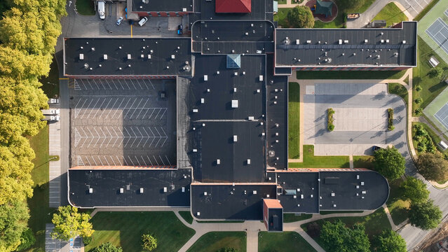 Aerial view of a large building complex with flat roofs, parking lots, and surrounding green spaces in Lancaster, Pennsylvania, United States.