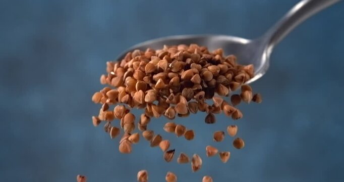 Buckwheat grains falling from a spoon in slow motion