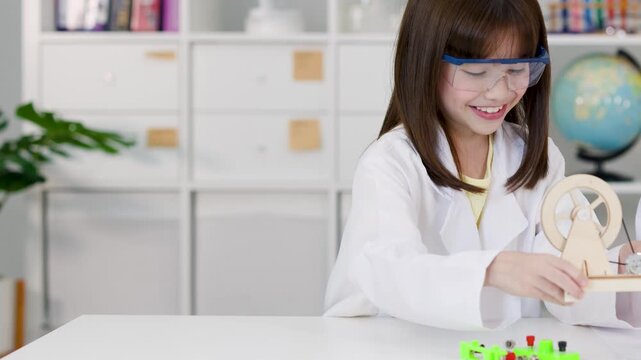 Young School Girl in Lab Coat Building Robotic Science Kit