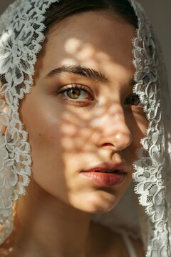 Retrato de primer plano de una mujer joven con un velo de encaje blanco y patrones de luces y sombras proyectados sobre su rostro