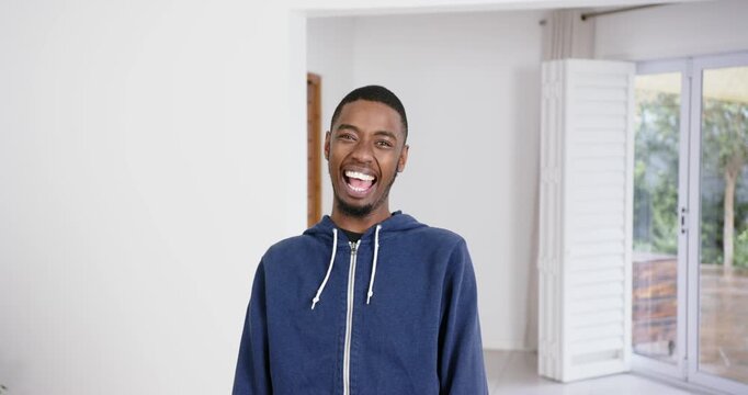 High speed photography for dynamic scenes, smiling man in blue hoodie standing indoors, expressing j