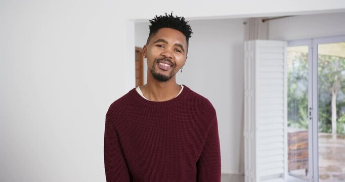 High speed photography for dynamic scenes, smiling man in casual sweater standing indoors, looking r