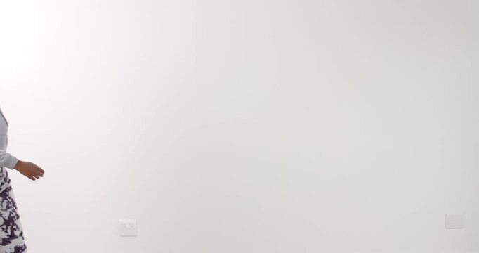 High speed photography for dynamic scenes, Smiling woman in casual wear standing against white backg