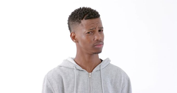 Young man in gray hoodie looking confused against white background