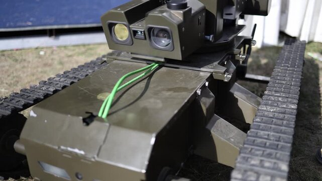 Military ground robot with tracked mobility and mounted weapon system uses optical sensors for remote surveillance reconnaissance and unmanned combat support missions