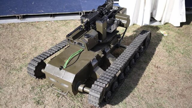 Unmanned tracked military robot equipped with machine gun optical sensors and remote weapon station showing compact robotic combat technology for tactical ground operations