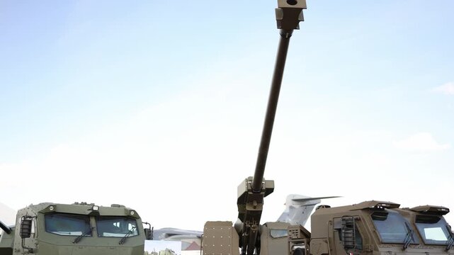 Self propelled military howitzer with long artillery barrel and armored crew cabin displayed outdoors showing modern mobile fire support and battlefield equipment