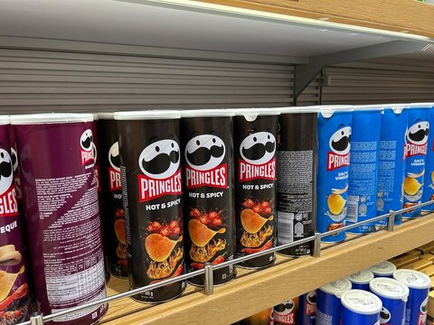 Pringles potato chips cans on grocery store supermarket shelf display stock photo editorial use image for retail and consumerism concepts