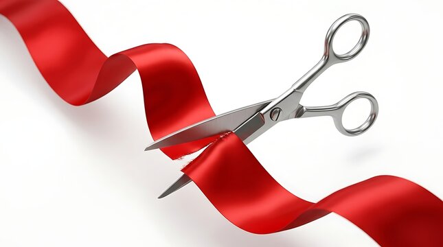 Large pair scissors cutting vibrant red ribbon in mid air