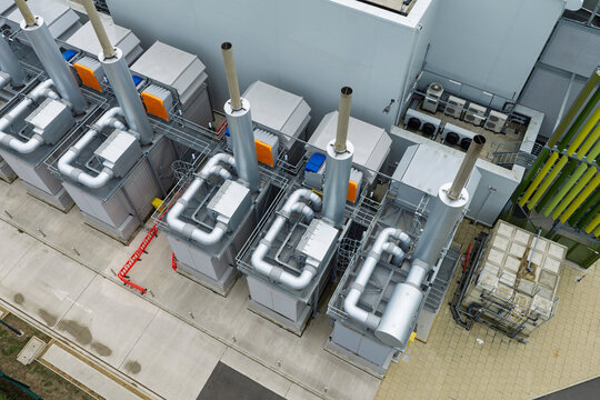 Aerial view of data center cooling units and industrial infrastructure with metal pipes, ventilation systems, and concrete flooring in the United Kingdom.