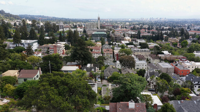 Aerial view of the University of California Berkeley campus and surrounding residential area with Sather Tower rising above the trees and buildings in Berkeley, California, United States.