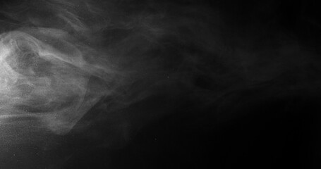 Obraz premium White smoke swirling and dissipating in dark background with wispy tendrils drifting across frame