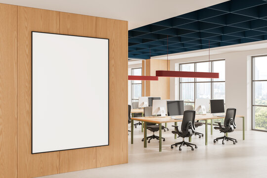 Modern office interior with blank poster mockup on wood wall, open workspace, desks, chairs, windows, and contemporary ceiling design. 3D Rendering