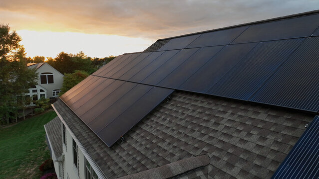 Aerial view of solar panels installed on a residential roof during golden hour in Warwick Township, Rothsville, Pennsylvania, United States.