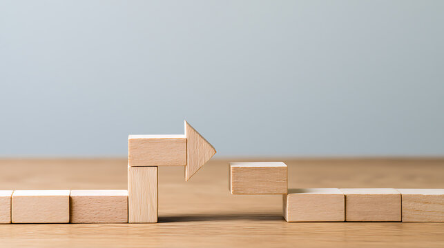 Wooden block puzzle with arrow shape bridging a gap, concept of problem solve strategy and business success plan to overcome obstacle