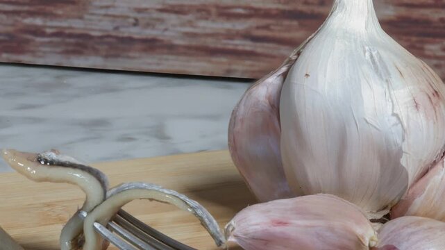 garlic on a wooden background anchovies