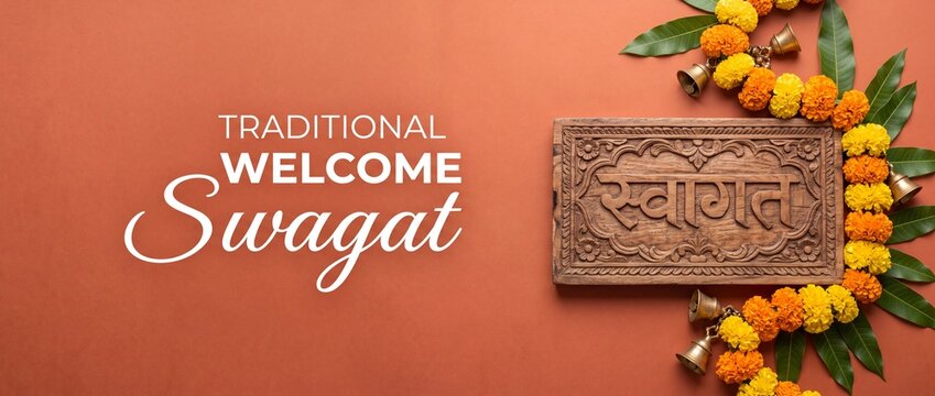 Indian welcome swagat sign board with wooden engraved hindi text, marigold flower garland, mango leaves, brass bells for diwali celebration, griha pravesh housewarming decoration banner background