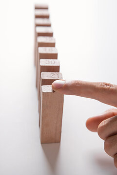 Male hand stopping wooden blocks from falling.