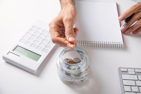 Man putting coin on jar. Finance