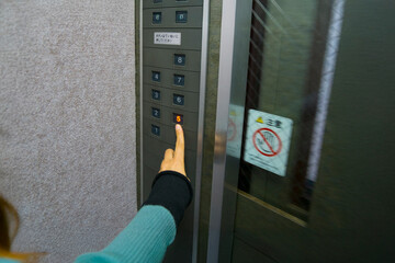 エレベーターのボタンを押す © Nii Koo Nyan