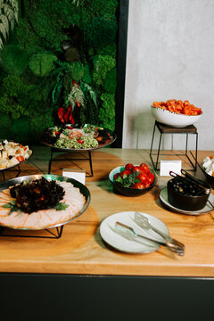 Fresh buffet of cold cuts and vegetables on a wooden restaurant table
