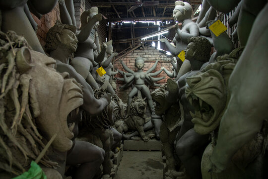 A serene yet melancholic view inside a congested Kumartuli workshop in Kolkata, filled with unfinished clay idols of Goddess Durga waiting for the upcoming Sharadotsav festival.