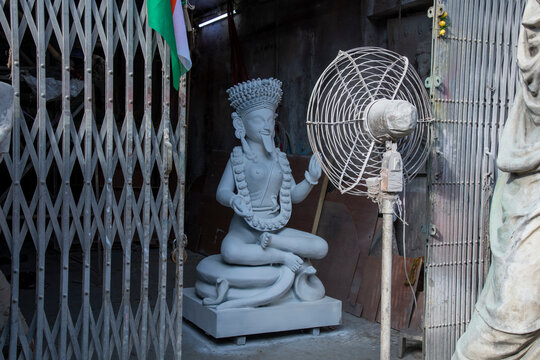 An artisan's workshop in Kolkata's historic Kumartuli district during the idol-making season. An unfinished clay sculpture of Goddess Kali sits in the traditional lotus position (Padma Asan mudra)