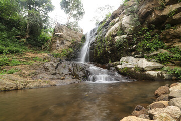 Small waterfall flowing rocks forest pond © Tantra