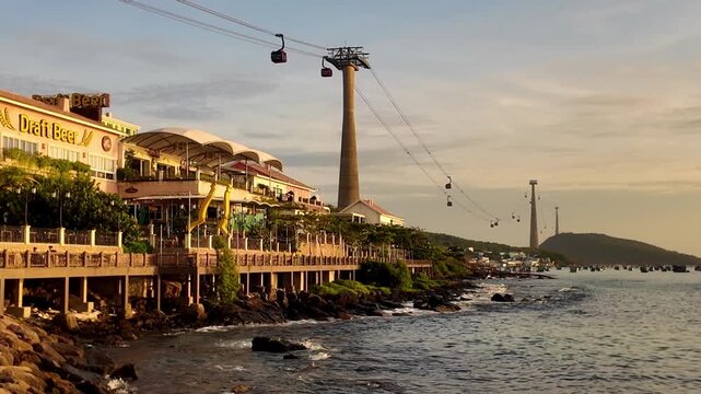Slow pan shot of the Hon Thom cable car and coastal promenade at sunset in Phu Quoc Vietnam