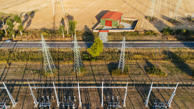 Aerial view of electrical substation with high voltage power lines and transmission towers situated next to a rural road and agricultural fields in Sremska Mitrovica, Vojvodina, Serbia.