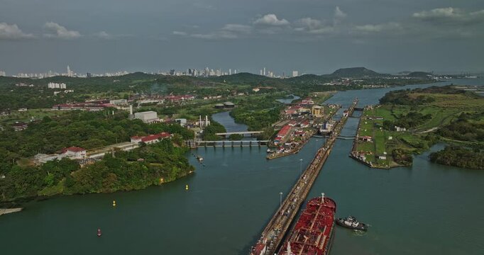Panama City Aerial v32 establishing drone flyover miraflores lake with cargo ship transiting at canal locks with downtown cityscape in the background - Shot with Mavic 3 Cine - March 2022