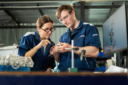 Engineers Examining Mechanical Component in Manufacturing Factory