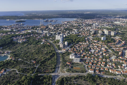 Aerial view of Pula and Pjescana Uvala featuring residential areas, dense forests, and the Adriatic Sea coastline, Pula, Pjescana Uvala, Istarska zupanija, Croatia.